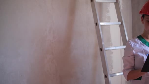 Дизайнер интерьера в квартире делает заметку для подготовки ремонта — стоковое видео