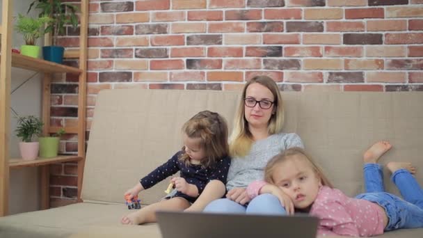 Mother with sad daughters looking in laptop at home — Stock Video