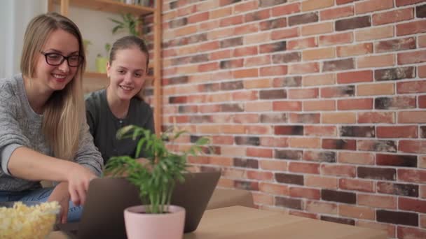 Mère avec sa fille assise sur le canapé et regardant la série — Video