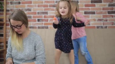 Evde dizüstü bilgisayara bakan üzgün kızları olan bir anne.