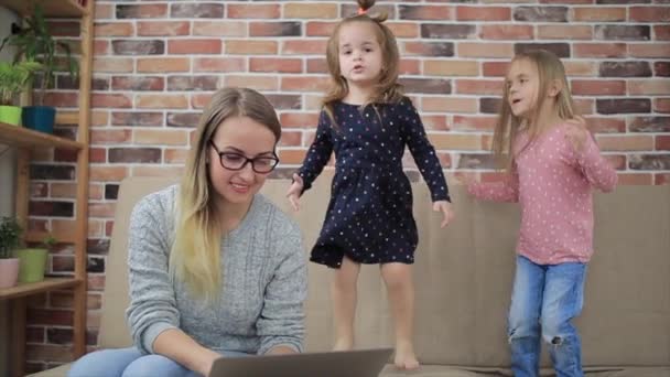 Madre con hijas tristes mirando en el ordenador portátil en casa — Vídeo de stock