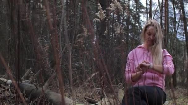 Woman looking compass on smartwatch in the forest — Stock Video