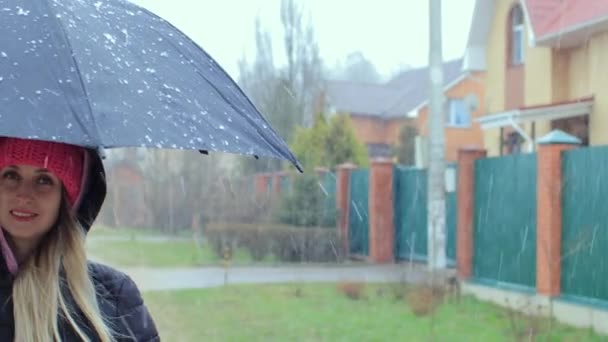 Chica con paraguas que permanece en el día lluvioso ventoso en el camino rural — Vídeos de Stock