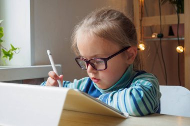 Tabletli ve stil öğrenen küçük kız çevrimiçi resim yapıyor.