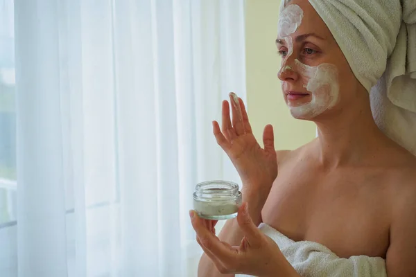 Wanita setelah kamar mandi menerapkan masker spa di wajahnya — Stok Foto