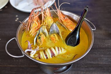 Hindistan cevizi sütü soslu baharatlı deniz ürünleri. Sıcak bir tencerede yakın plan..