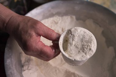 Elin dolu bir bardak un tutuyor..