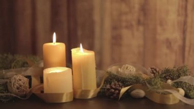 Üç yanan mum, çam dalları, doğal çam kozalakları, altın saten ve beyaz organza kurdeleli Noel ayarı