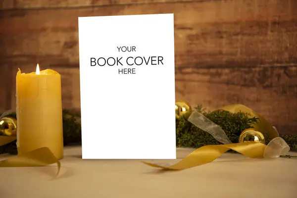 Karácsonyi díszlet egy könyv bemutatóra: könyv üres borító telepedett három gyertyák, fehér organza és arany szatén szalagok, arany baubles világos fa asztal és sötét fa háttér — Stock Fotó