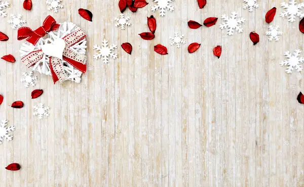 Mieszkanie leżały zniszczone przestrzeni Christmas kopia z białymi drewnianymi płatkami śniegu, czerwone płatki i białe drewniane dekoracyjne serce w lewym górnym rogu na jasnym drewnianym tle — Zdjęcie stockowe