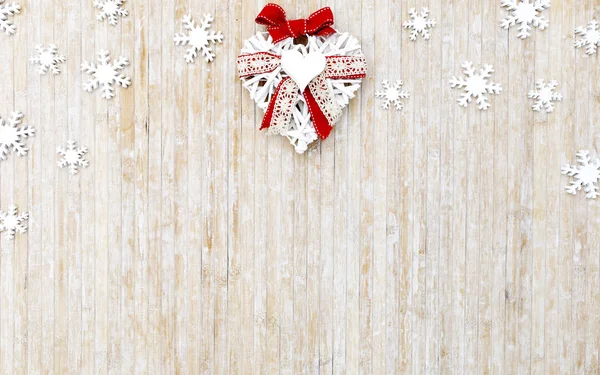 Mieszkanie leżało zniszczone przestrzeni Christmas kopia z białymi drewnianymi płatkami śniegu i białe drewniane dekoracyjne serce w górnej części środkowej na jasnym drewnianym tle — Zdjęcie stockowe