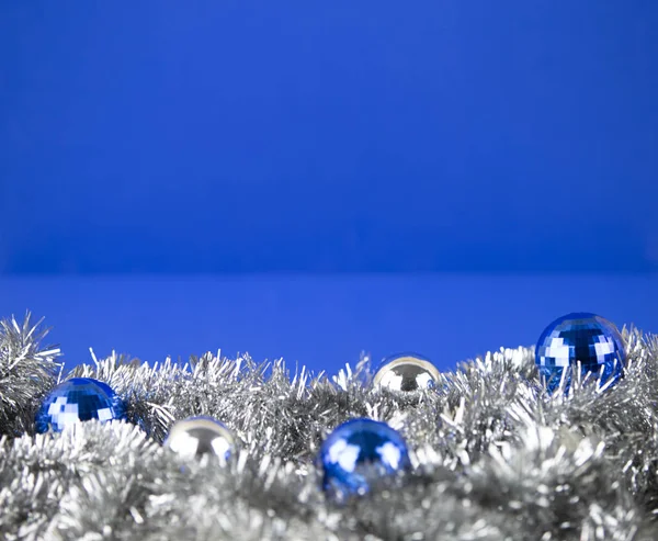 Weihnachten Kopierraum mit blauen und silbernen hellen Kugeln in silbernen dekorativen Kette Girlande auf blauem Hintergrund mit Bokeh-Effekt — Stockfoto
