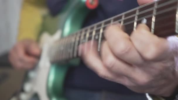 金属製の緑のヴィンテージエレクトリックギターでコード スケール ソロを演奏首にギターマスターの手のスライドのクローズアップ — ストック動画