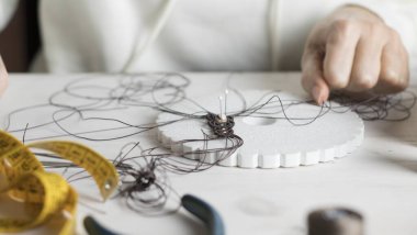 Yaşam tarzı konsepti, hayatınızı yeniden keşfetmek için evden çalışmak: kadın ellerine yakın plan taş boncuklar ve açık ahşap masa üzerinde aletler ile makrome düğümlenmiş mücevherler yapmak