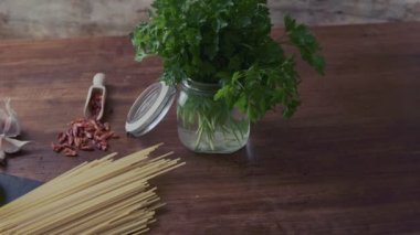 Tipik İtalyan spagetti aglio olio e peperoncino (sarımsak, yağ ve acı biber) malzemelerinin sağdan sola doğru yakın çekimi.