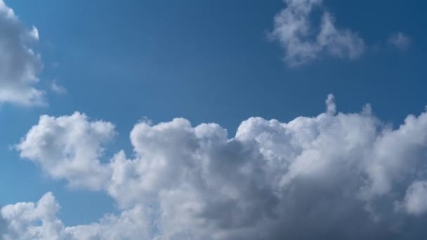 青い空の左から右へと連続的に流れる白いふわふわの雲のシームレスな時間の経過 — ストック動画