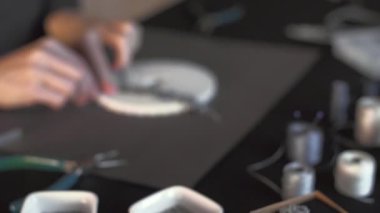 Yaşam tarzı konsepti, hayatınızı ve işinizi yeniden oluşturun: ön plandaki makrome bilekliğin düşük açılı görüntüsü ve arka plandaki ipliği bokeh etkisi ile düğümleyen kadın elleri