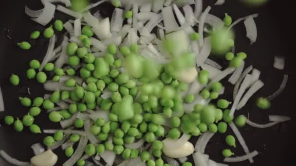 慢动作把豌豆倒入一个盛满油 洋葱和大蒜的平底锅中 效果很好 地中海土制烹调 — 图库视频影像