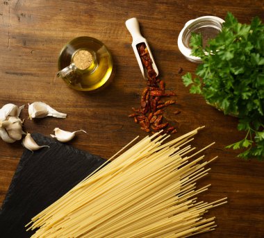 Tipik İtalyan spagetti aglio olio e peperoncino (sarımsak, yağ ve acı biber) malzemelerinin düz bir görünümü vardı.