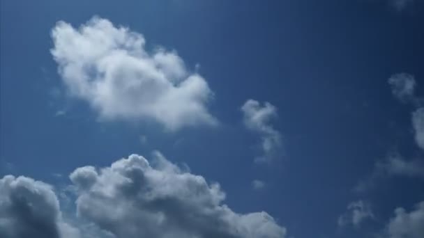 4k uhd ciel bleu laps de temps de nuages blancs pelucheux dans le mouvement de la lumière arrière 
