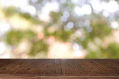 Soyut bulanık yeşil Bokeh Ligh 'in önündeki boş ahşap masa