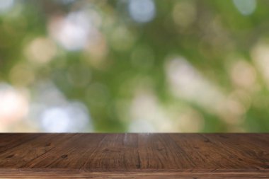 Soyut bulanık yeşil Bokeh Ligh 'in önündeki boş ahşap masa