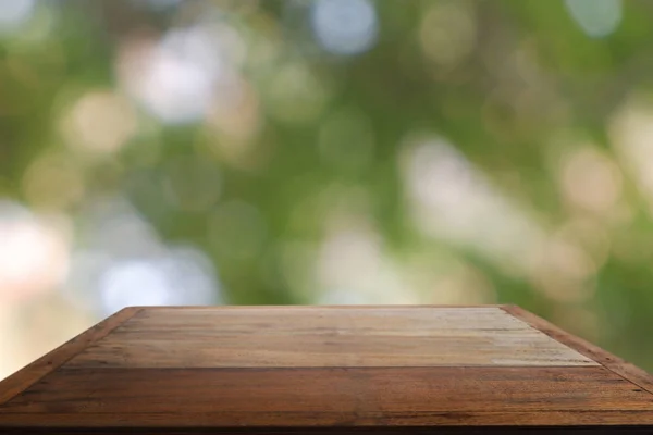 Empty wooden table in front of abstract blurred green bokeh ligh of garden and nature light background. For montage product display or design key visual layout - Image