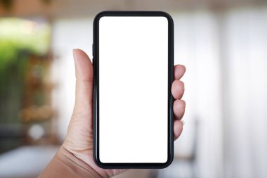 Yakın plan el ele tutuşmalar, ev ve kafenin arka planında bulanıklık olan akıllı telefonlar, kopyalama alanı..