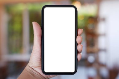 Yakın plan el ele tutuşmalar, ev ve kafenin arka planında bulanıklık olan akıllı telefonlar, kopyalama alanı..