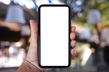 Yakın plan el ele tutuşmalar, ev ve kafenin arka planında bulanıklık olan akıllı telefonlar, kopyalama alanı..