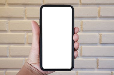 Telefonu dikey tutarak, beyaz tuğla duvar arka planına doğru akıllı telefon kullanarak - boşluğu kopyala.