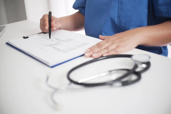Doktor masasında çalışıyor. Steteskopa odaklan. Geçmişini ameliyat eden kadın tıp doktoru. Sağlık ve Tıbbi Konsept Kopyalama Alanı.