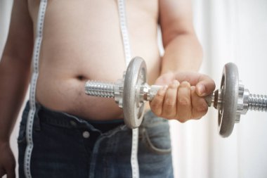 Şişman adamlar ağırlık kaldırarak egzersiz yapmaya başlarlar..