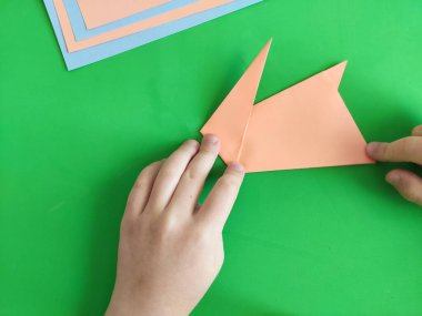 Origami adım adım. Paskalya kutlamaları ve eğlence için kağıttan tavşan yapmayı. Diy kavramı. Çocukların el işçiliğinin kağıt işçiliğinin en üst görüntüsü. Adım adım fotoğraf talimatı. 11 üzerinden 6..