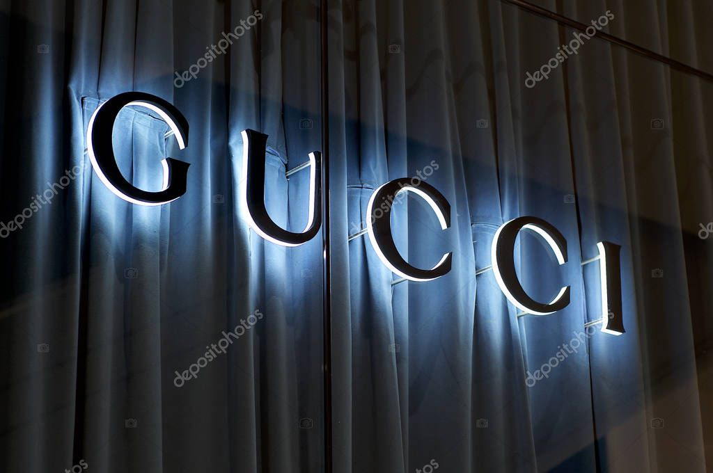 Brisbane, Queensland, Australia - 27th November 2019 : View of the Illuminated Gucci sign on a glass wall with blue curtain in Brisbane. Gucci is know for his luxury leather and fashion goods.