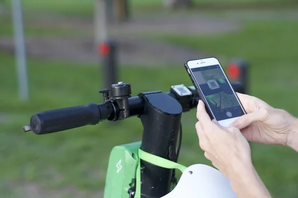 Limonlu e-scooter gidonu ve cep telefonu taramaya hazır.