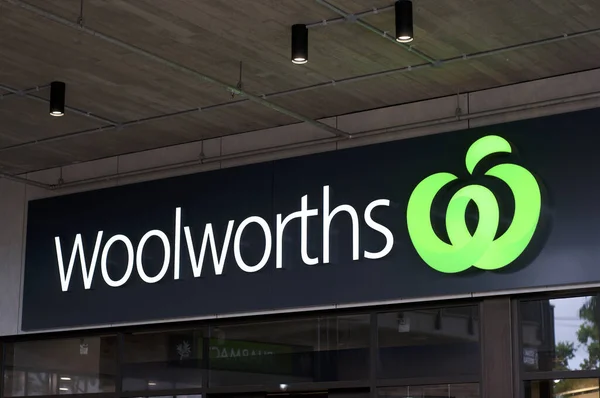 Byron Bay, New South Wales, Australia - 10th February 2020 : Glowing Woolworths sign hanging in front of the store entrance in Byron Bay, Australia