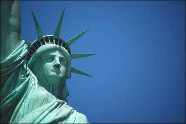Özgürlük Heykeli 'nin (Dünyayı Aydınlatan Özgürlük Heykeli) New York' taki Özgürlük Adası 'nda mavi gökyüzüne karşı yakın bir resmi.