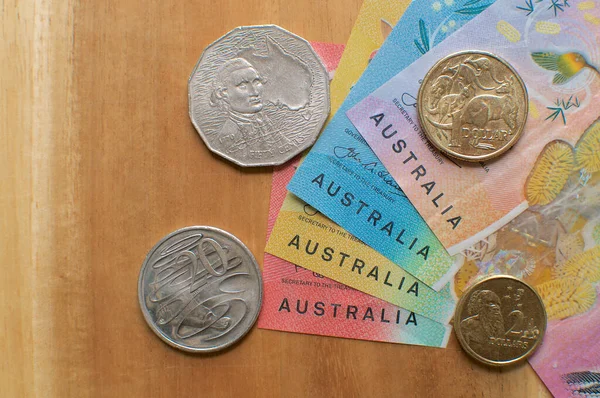 Close up picture of Australian banknotes and coins on a wooden table. Currency and money from Australia
