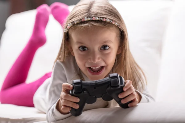 Little girl playing videogames at home — Stock fotografie