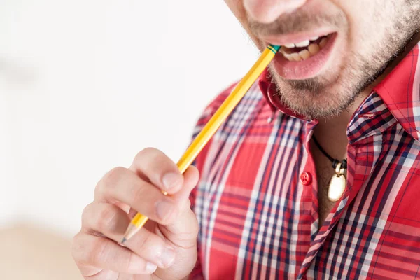 Man holding and biting a pencil — Φωτογραφία Αρχείου