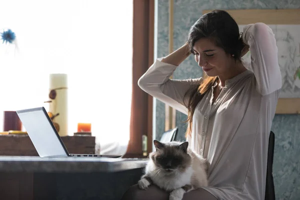 Jolie jeune femme se relaxant à la maison avec un chat — Photo