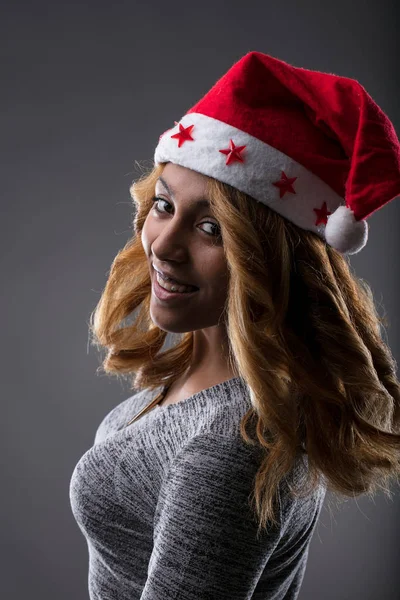 Afroamerican mulher sorrindo com um chapéu de Papai Noel — Fotografia de Stock