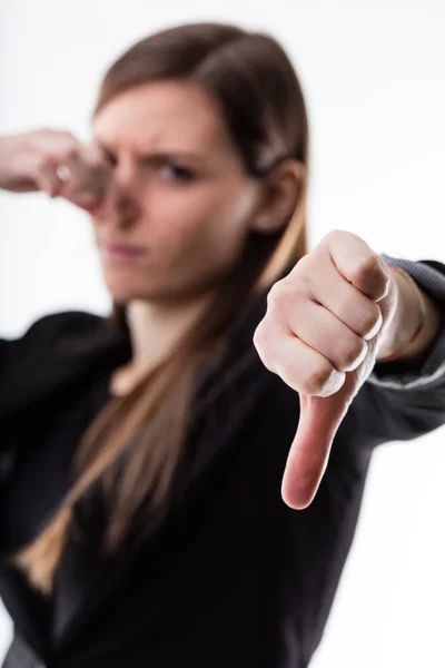 Thumb down of a woman blurred in the background — Stock Photo, Image