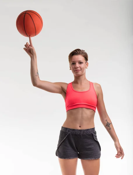 Женщина балансирует баскетбольный мяч на пальце — стоковое фото