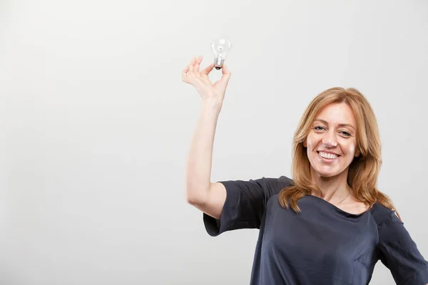 Настоящая женщина, держащая лампочку в воздухе — стоковое фото