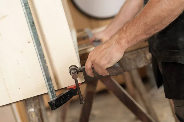 Hand clamping a wooden board or piece of furniture — Stock Photo, Image