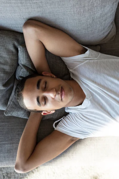 Jovem bonito com olhos fechados dormindo em seu sofá — Fotografia de Stock