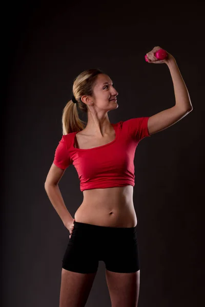 Stolt smilende kvinde løfte en lyserød vægtstang - Stock-foto