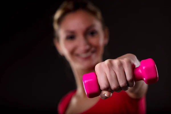 Mulher trabalhando com um halteres coloridos — Fotografia de Stock